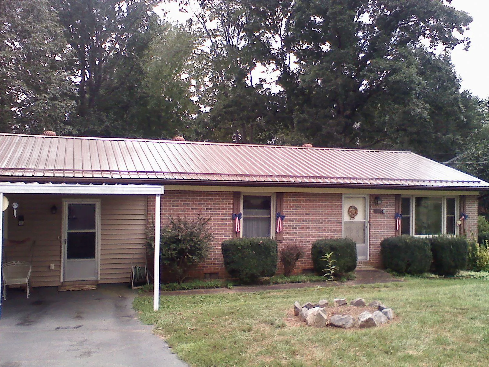 Bronze metal roof and carport on a brick ranch home — Roof Repair work by our crew in Effingham